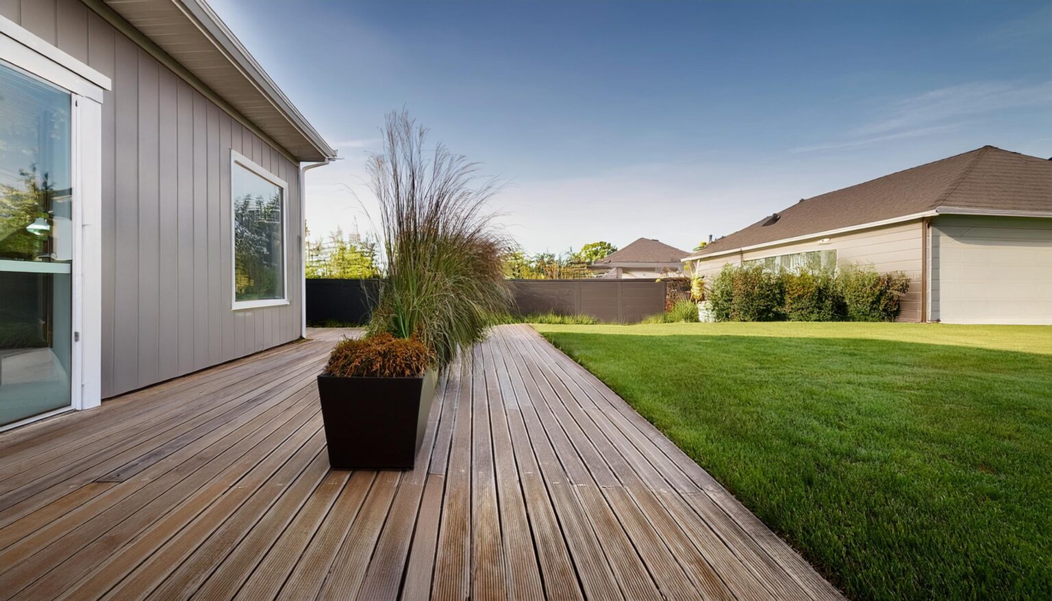 Terrasse en lames de bois créée le long d'une maison dans le Calvados